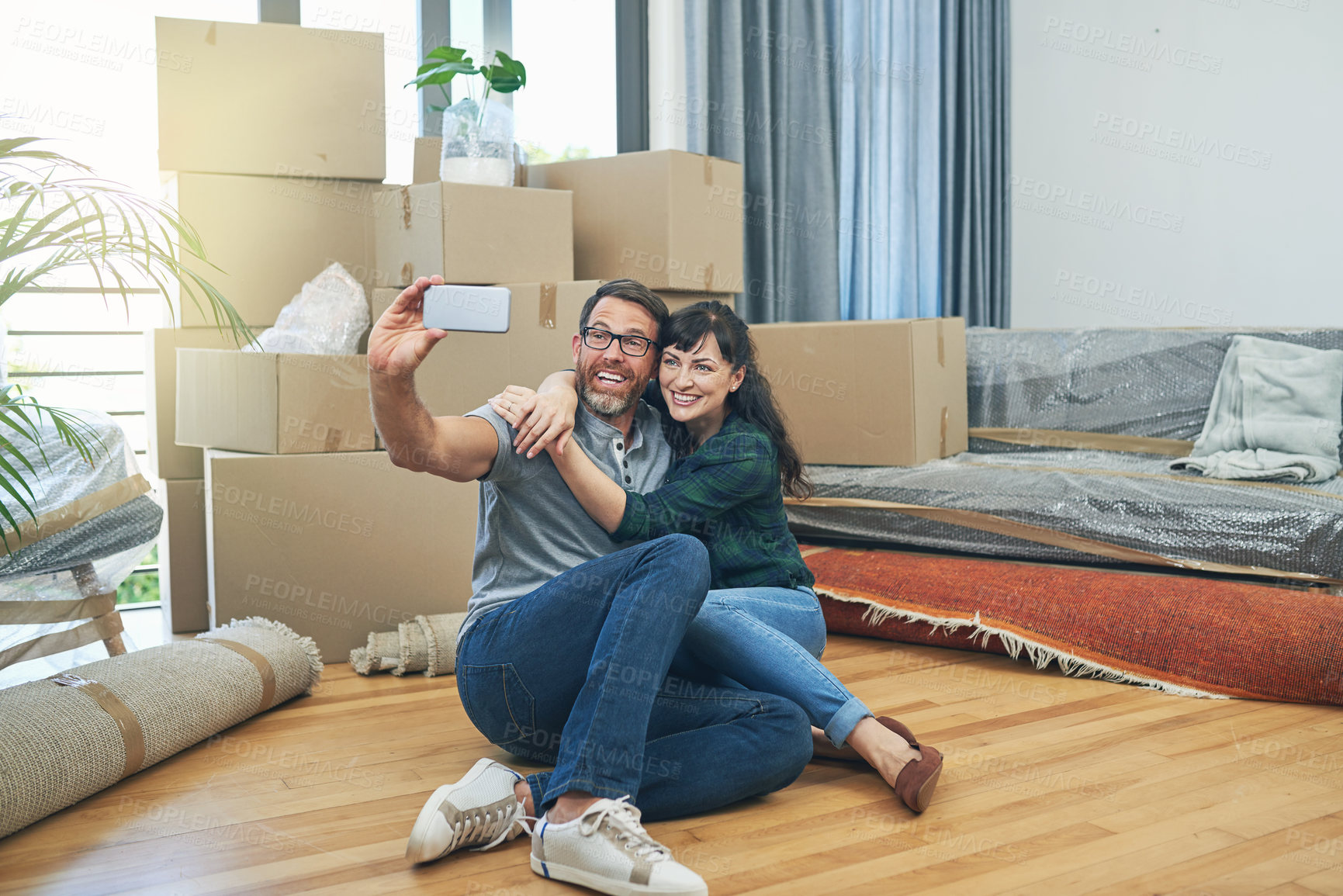 Buy stock photo Shot of a happy couple taking selfies together on moving day