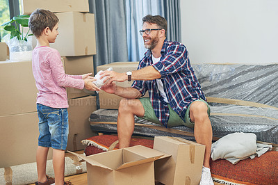 Buy stock photo Shot of an adorable little boy helping his father pack on moving day