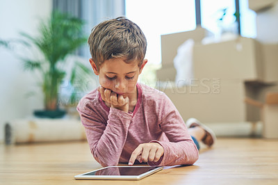 Buy stock photo Shot of an adorable little boy using a digital tablet at home on moving day