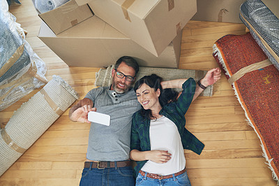 Buy stock photo High angle shot of a happy couple taking selfies together on moving day
