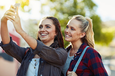 Buy stock photo Cropped shot of two beautiful female friends taking a selfie in the city