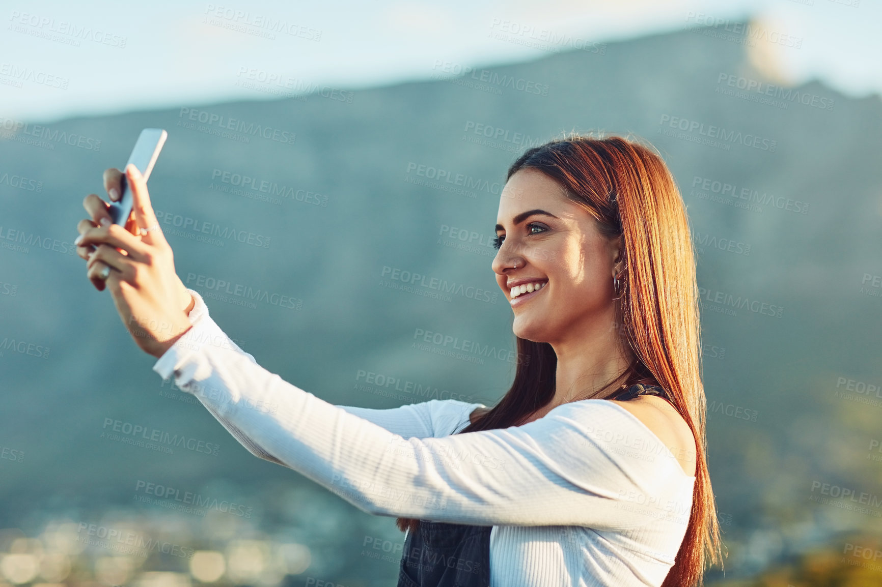 Buy stock photo Cropped shot of a beautiful young woman taking a selfie  in nature