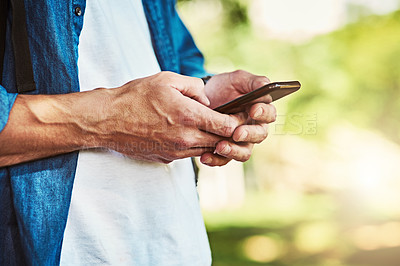 Buy stock photo Closeup shot of an unrecognizable man using a cellphone outdoors