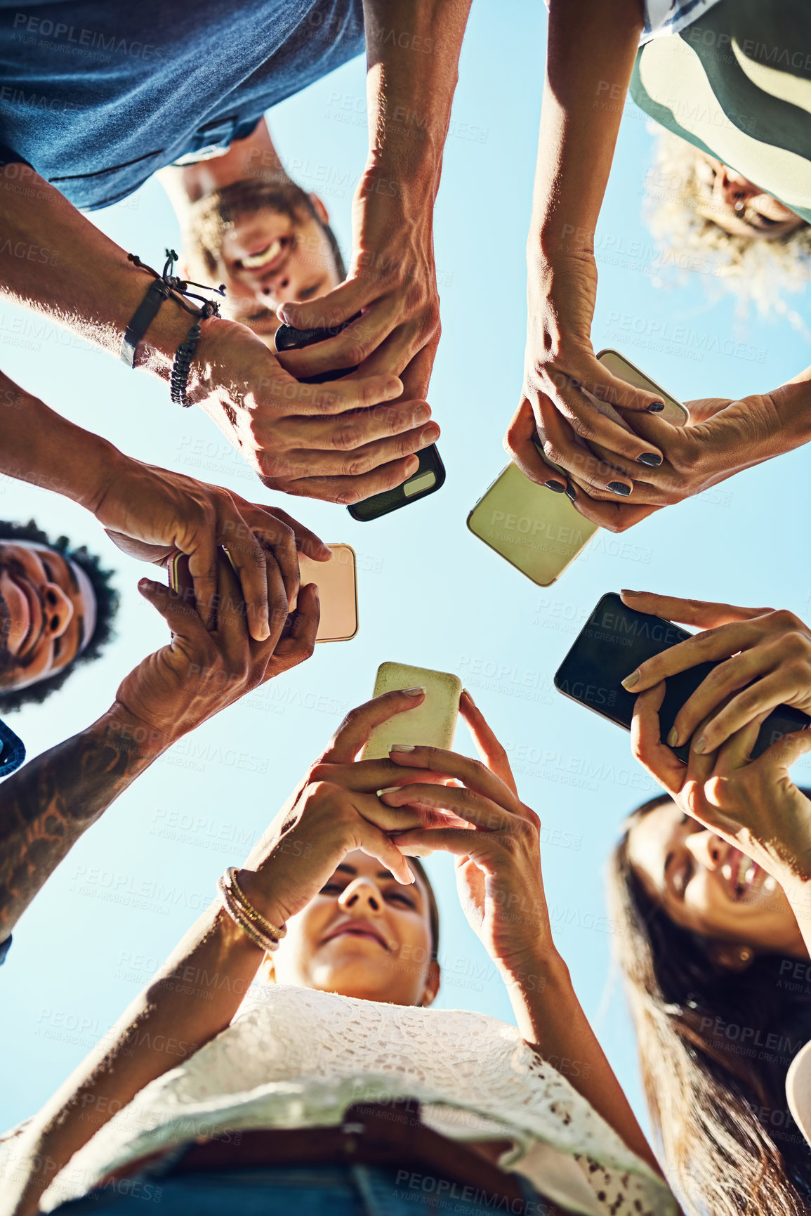 Buy stock photo Low angle, phone and hands with people, circle and communication or connectivity. Friends, social media and information sharing with diverse, group and standing in huddle outdoors in nature park