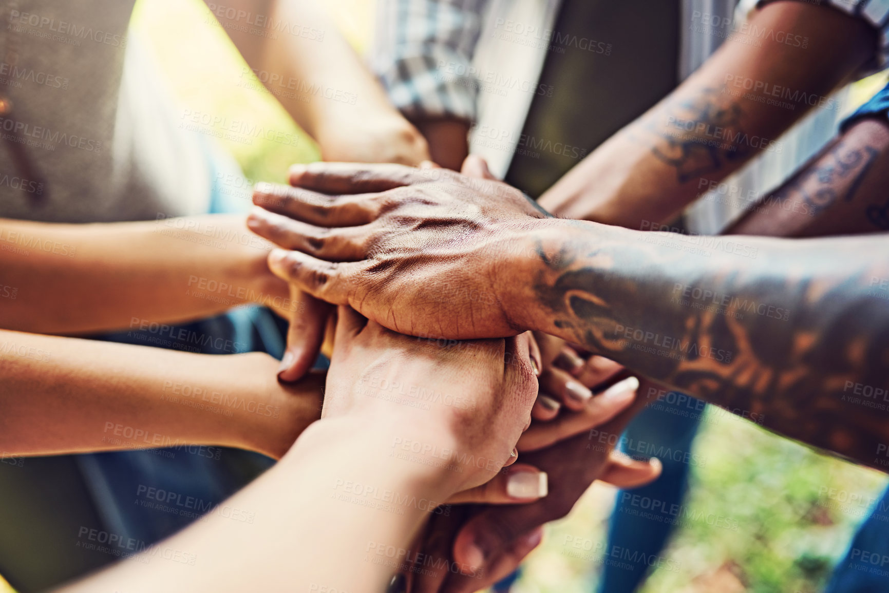 Buy stock photo Closeup shot of an unrecognizable group of people joining their hands in a huddle outdoors