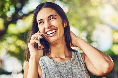 Buy stock photo Shot of an attractive young woman talking on a cellphone outdoors