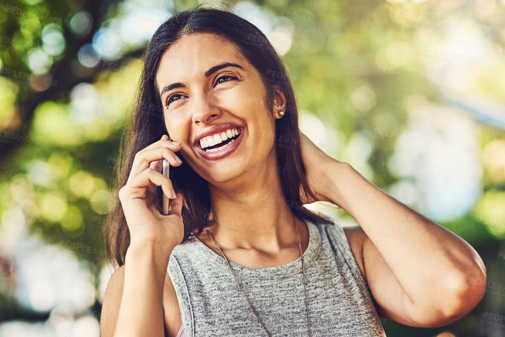 Buy stock photo Shot of an attractive young woman talking on a cellphone outdoors