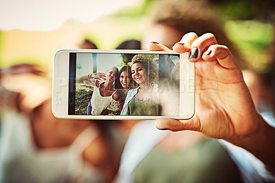 Buy stock photo Shot of a group of friends taking a selfie together outdoors