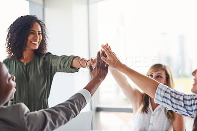 Buy stock photo Cropped shot of a group of businesswomen giving each other a high five in the office
