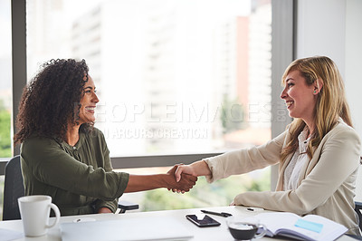 Buy stock photo Cropped shot of businesswomen shaking hands in the office