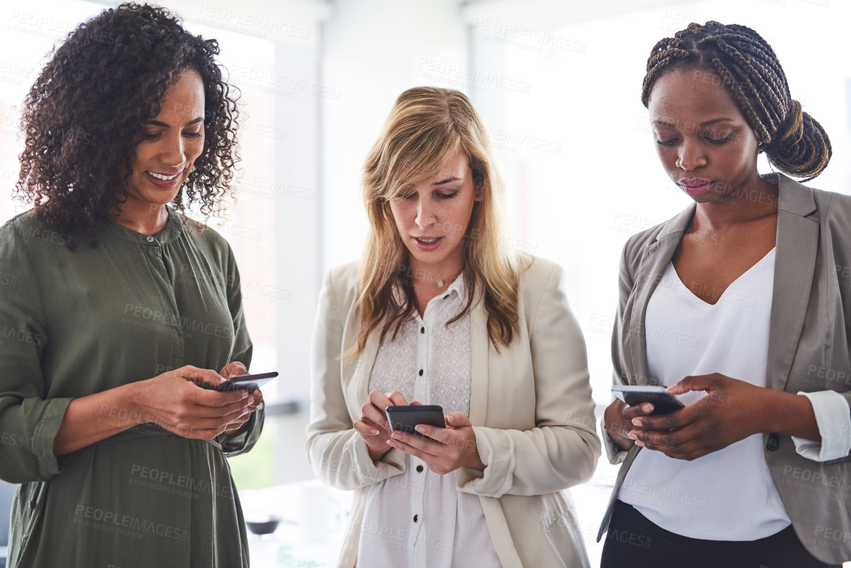 Buy stock photo Cropped shot of a group of businesswomen using cellphones in the office
