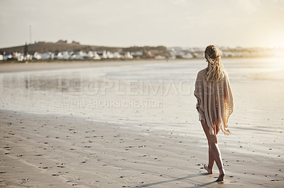 Buy stock photo Rearview shot of a young woman walking along the seashore