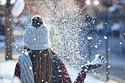 Buy stock photo Rearview shot of a young woman throwing snow on a wintery day outdoors