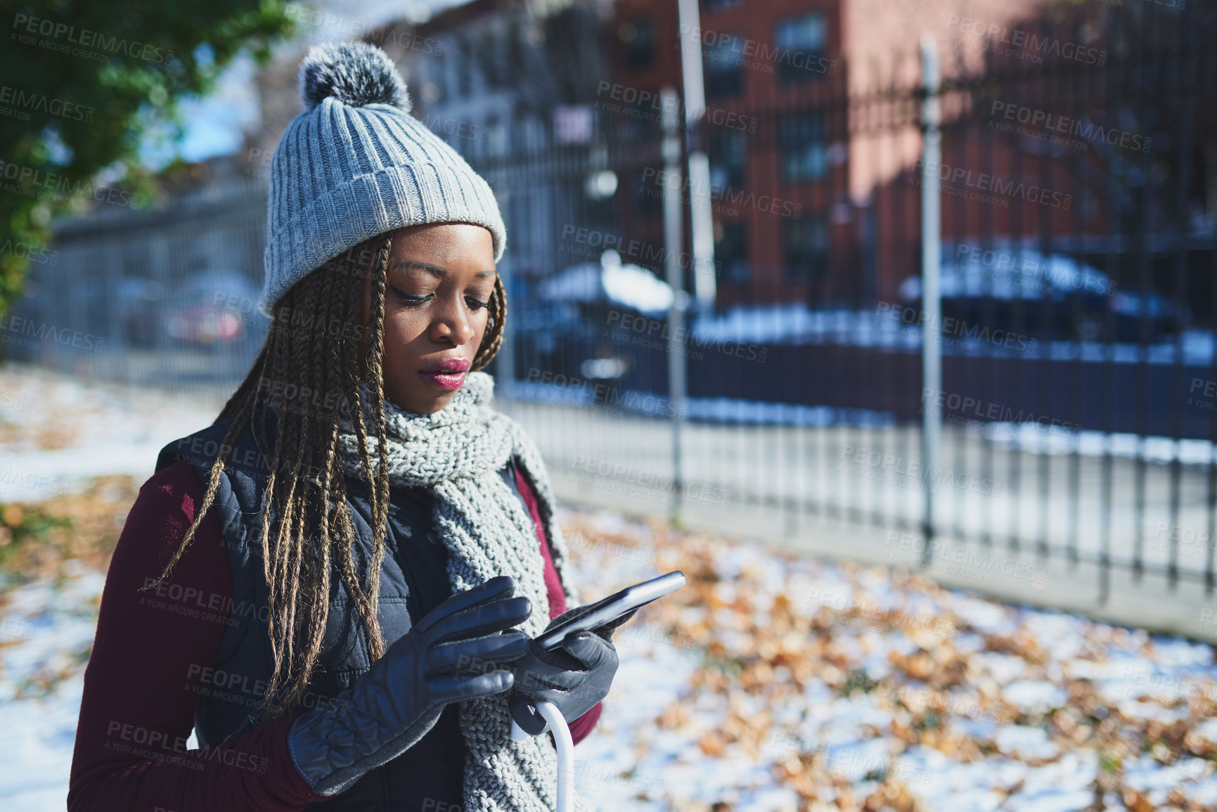 Buy stock photo Shot of a beautiful young woman using a mobile phone on a snowy day outdoors