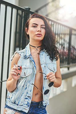 Buy stock photo Portrait of a beautiful young trendy woman smoking a cigarette outside