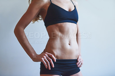 Buy stock photo Cropped shot of an unrecognizable young female athlete standing with her hands on her hips