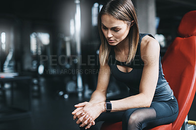 Buy stock photo Shot of an attractive young woman looking thoughtful during a workout in the gym