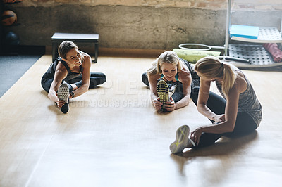 Buy stock photo Shot of mature women stretching with a young female instructor during a training class at the gym