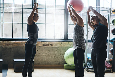 Buy stock photo Shot of mature women stretching with a young female instructor during a training class at the gym