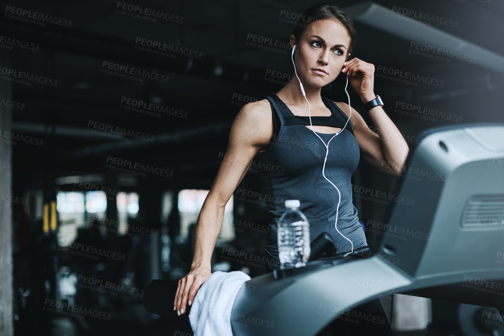 Buy stock photo Shot of an attractive young woman working out on a treadmill in a gym