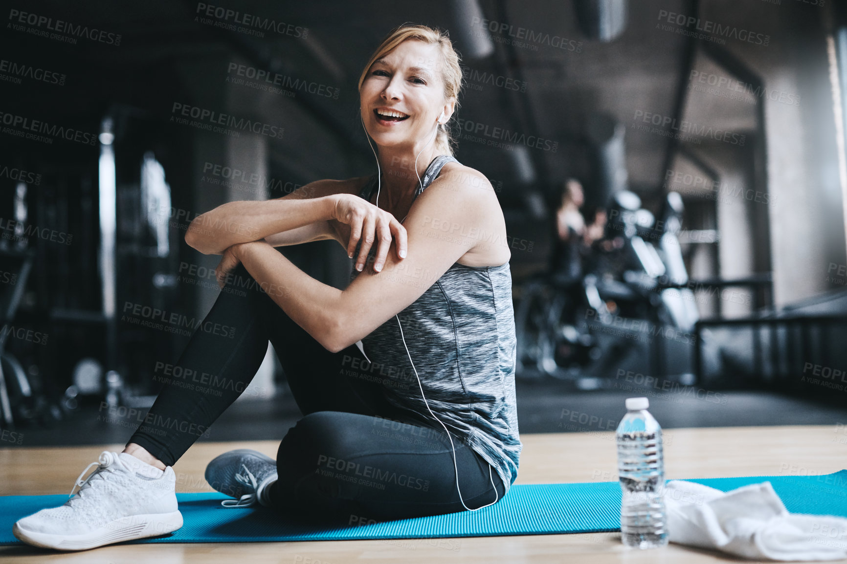 Buy stock photo Full length portrait of an attractive young woman listening to music while working out in the gym