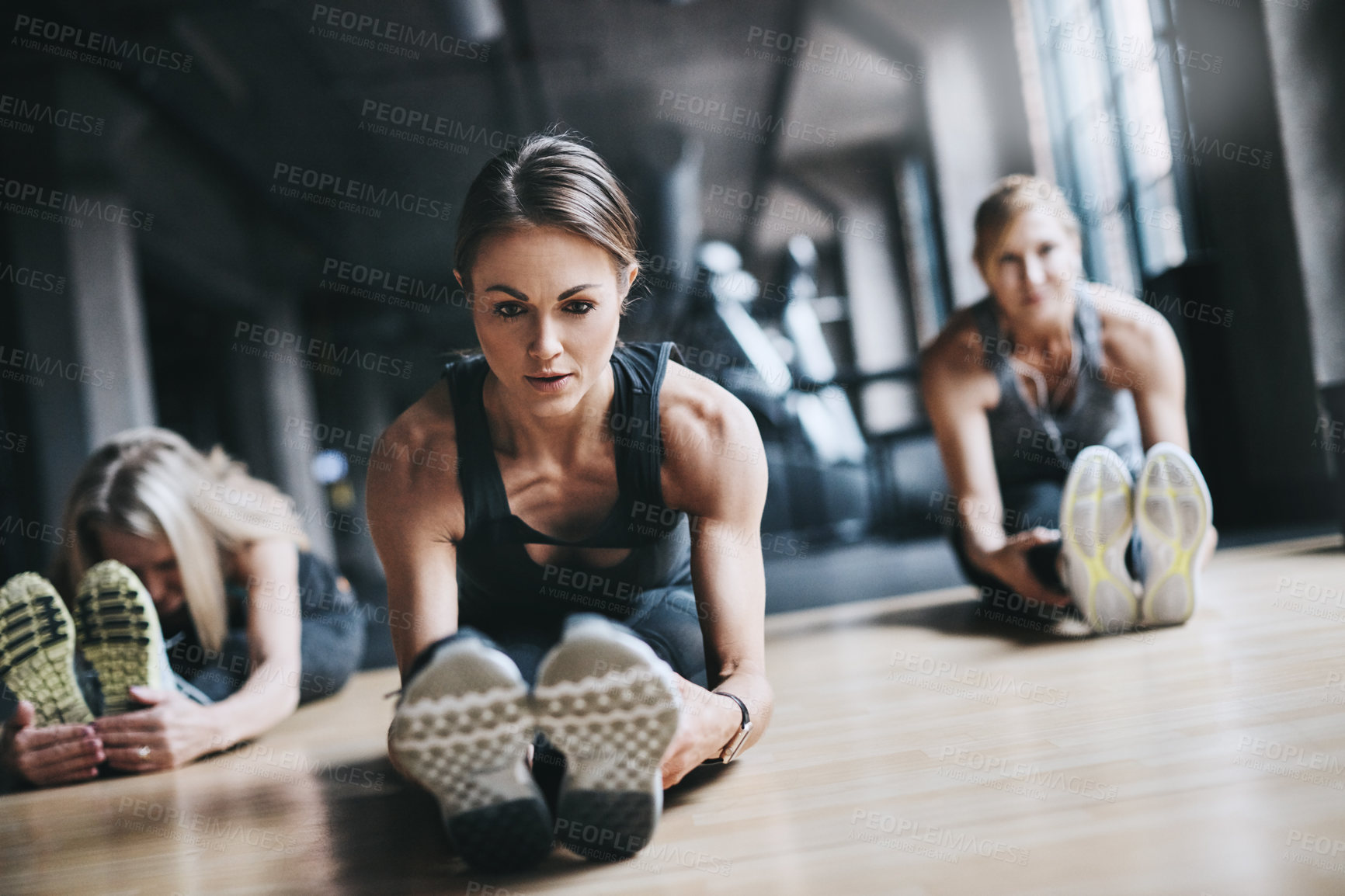 Buy stock photo Stretching legs, exercise and women in gym for workout, training and warm up on floor for mobility. Fitness, friends and people for wellness, health and flexibility for performance or muscle strength