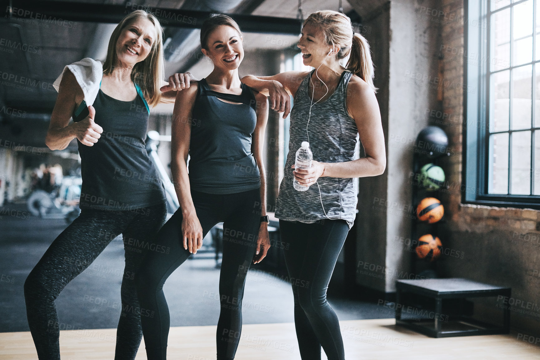 Buy stock photo Cropped shot of three attractive and athletic women working out in the gym