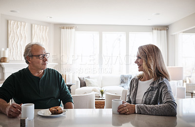 Buy stock photo Shot of a mature couple having coffee and a snack together during a relaxed day at home