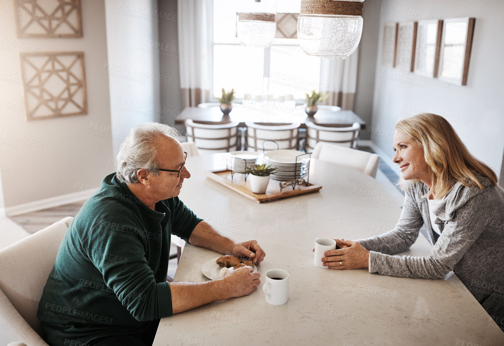 Buy stock photo Shot of a mature couple having coffee and a snack during a relaxed day at home