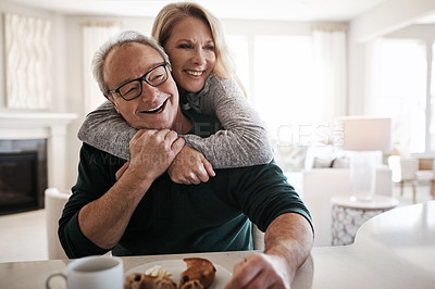 Buy stock photo Shot of an affectionate mature couple having coffee and a snack together during a relaxed day at home