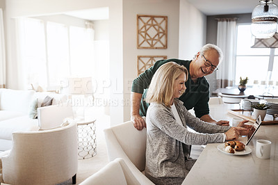 Buy stock photo Shot of a mature woman using a digital tablet during a relaxed morning at home