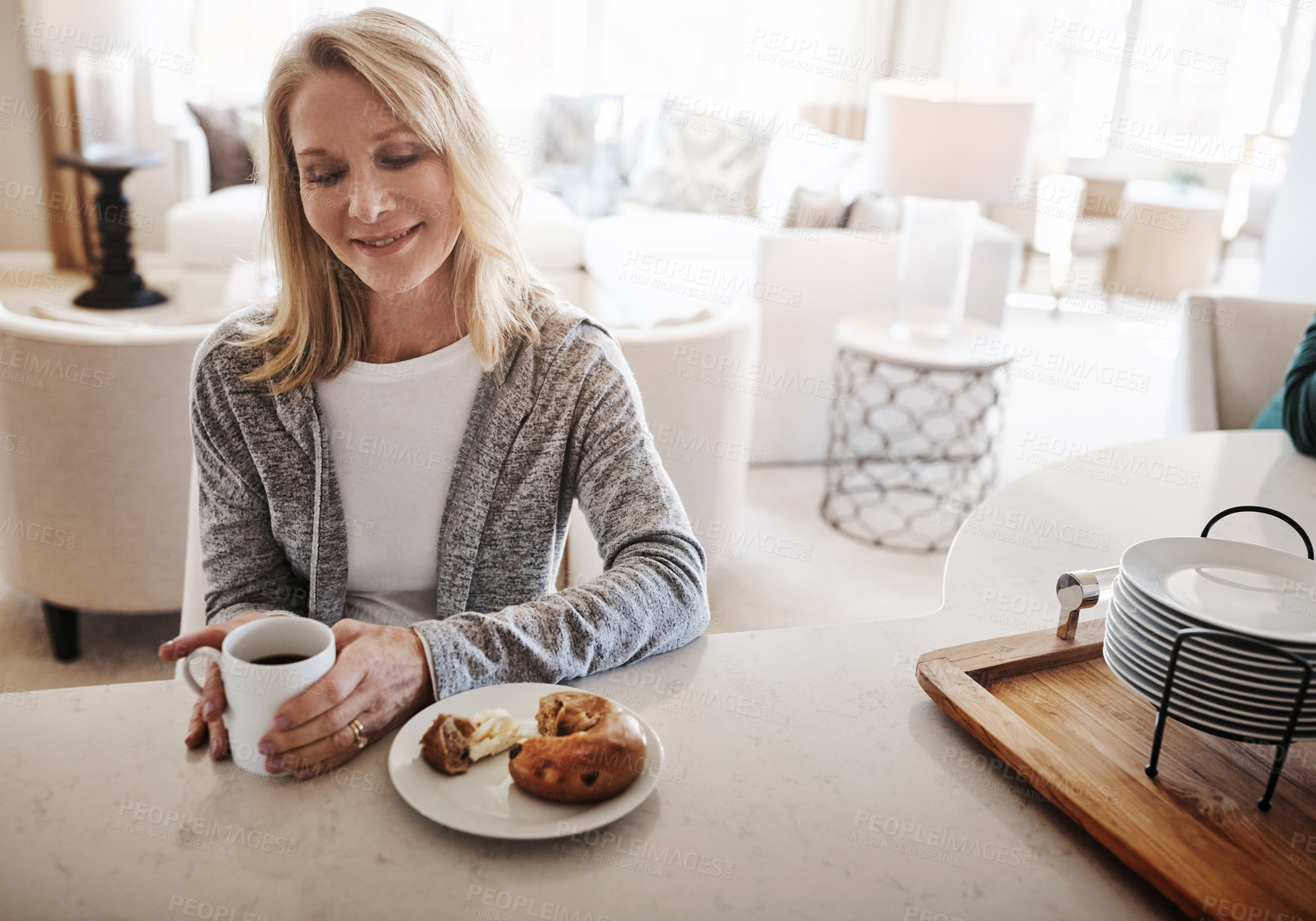 Buy stock photo Shot of a mature woman having coffee and a snack during a relaxed day at home