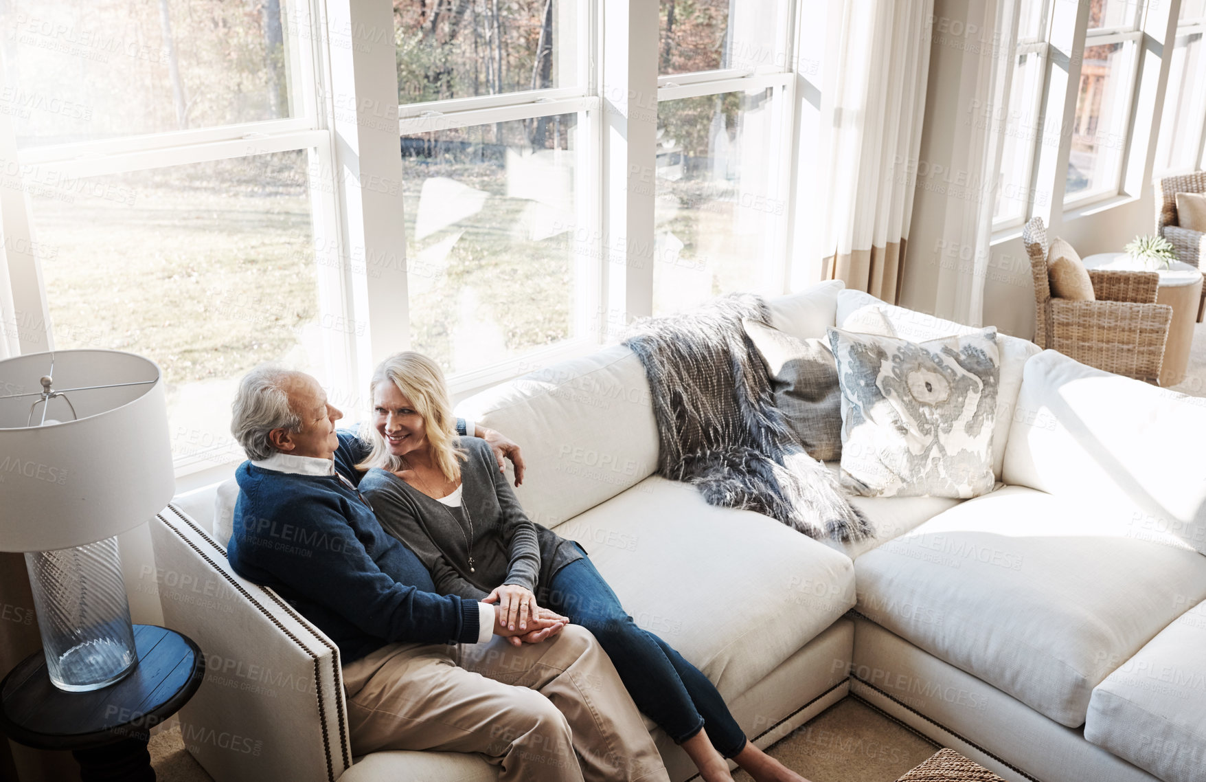 Buy stock photo Shot of a loving mature couple relaxing together at home