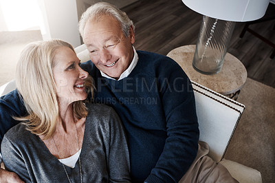 Buy stock photo Shot of a loving mature couple relaxing together at home
