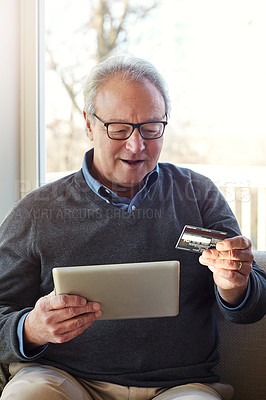 Buy stock photo Cropped shot of a senior man using a tablet and credit card at home