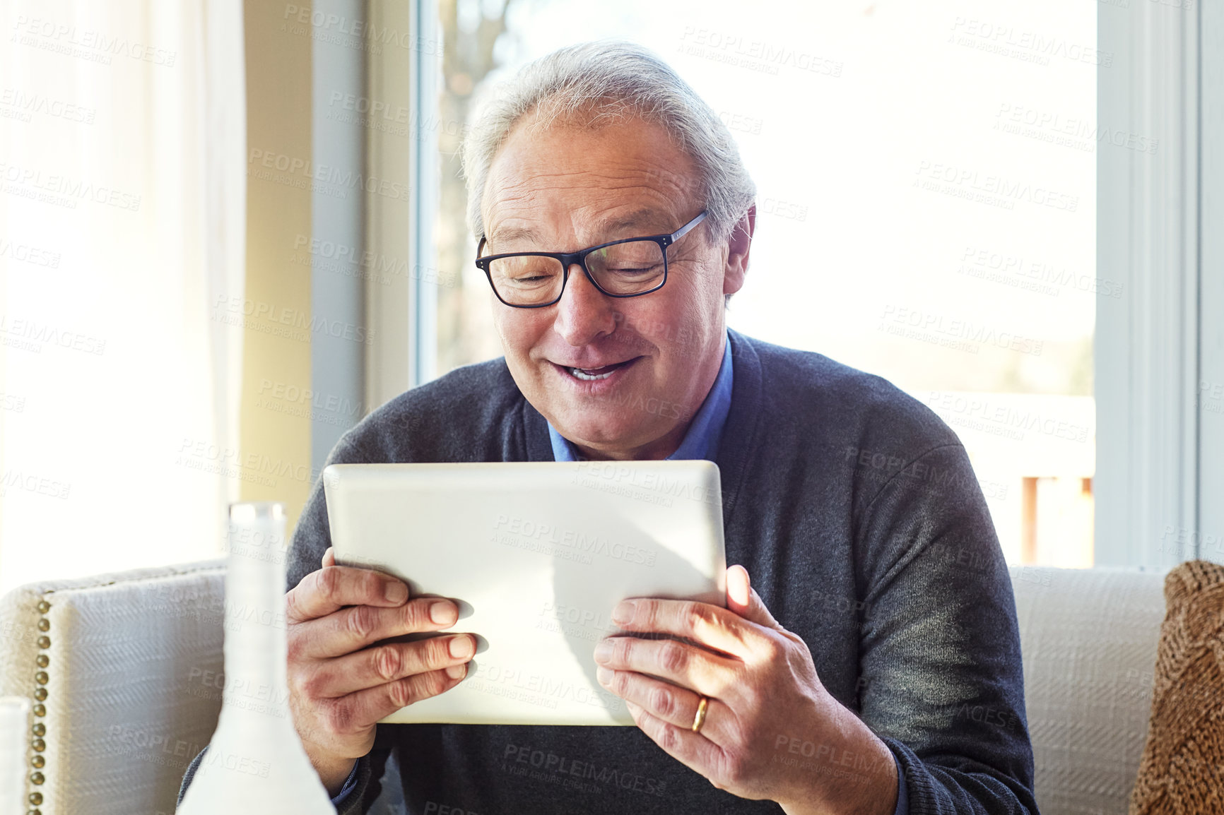 Buy stock photo Cropped shot of a senior man using a tablet at home