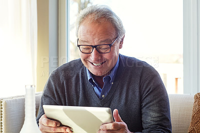 Buy stock photo Cropped shot of a senior man using a tablet at home