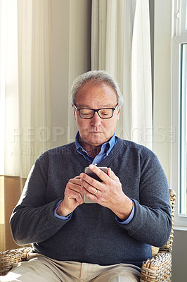 Buy stock photo Cropped shot of a senior man using a cellphone at home