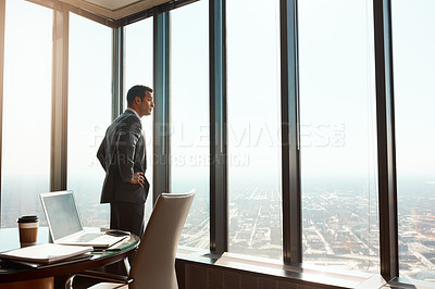 Buy stock photo Cropped shot of a handsome young businessman standing with his hands on his hips in the office