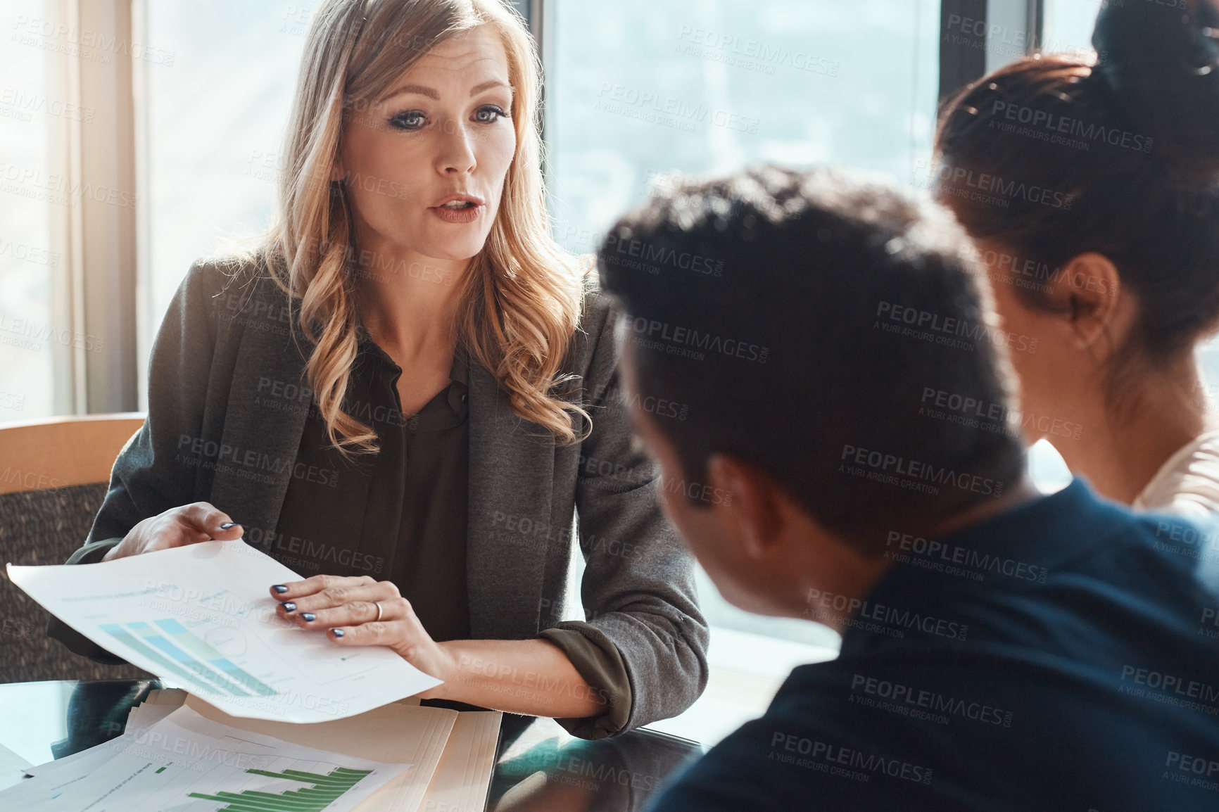 Buy stock photo Shot of a young couple meeting with a financial planner in a modern office