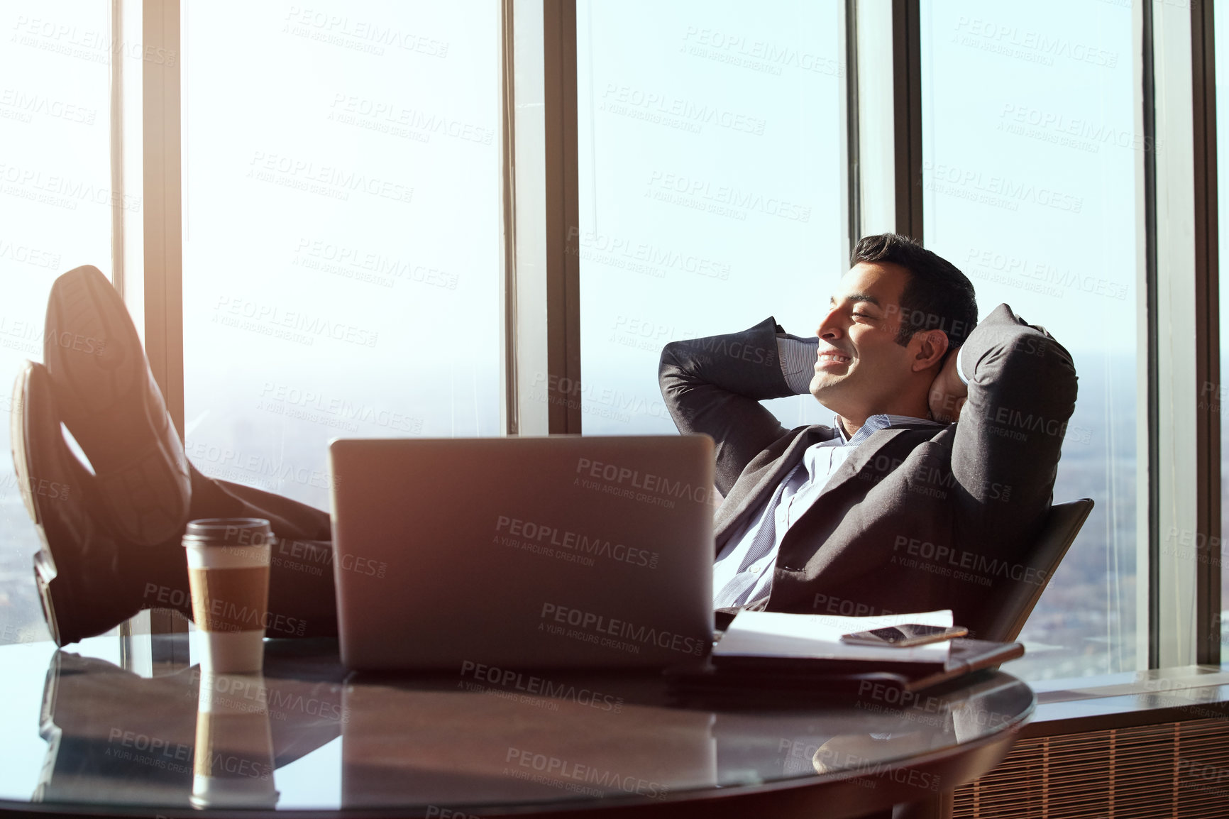 Buy stock photo Cropped shot of a handsome young businessman looking relaxed while sitting in his office
