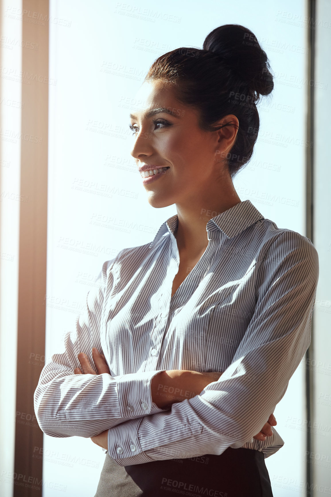 Buy stock photo Cropped shot of an attractive young businesswoman standing with her arms folded in the office