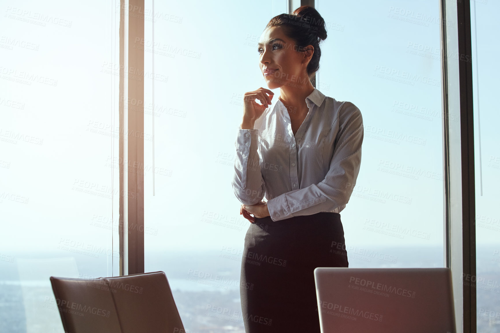 Buy stock photo Cropped shot of an attractive young businesswoman looking thoughtful while standing in her office