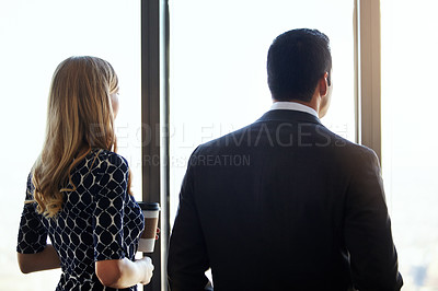 Buy stock photo Rearview shot of two young businesspeople standing in their office