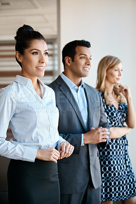 Buy stock photo Cropped shot of three young businesspeople standing in their office