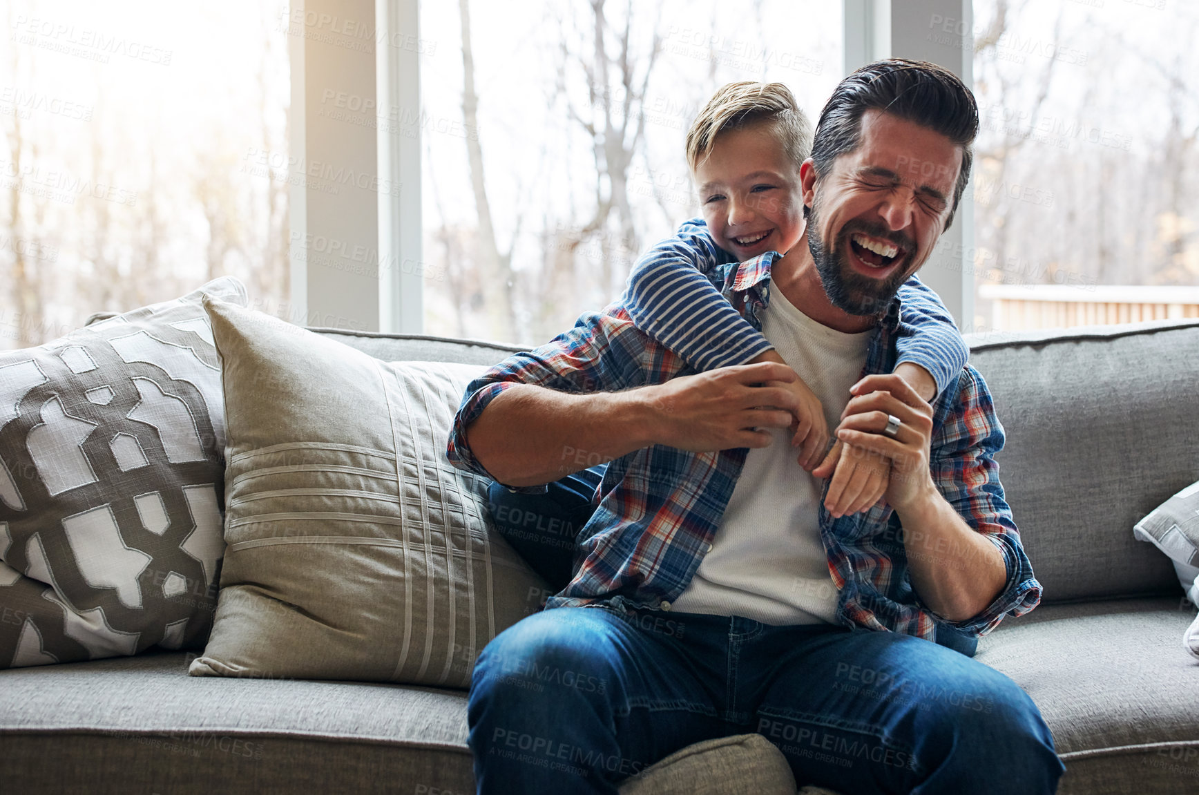 Buy stock photo Laugh, dad and kid with playing on sofa for bonding together, healthy relationship and funny game. Humor, father and happy boy with hug in home for playful connection, support and child development