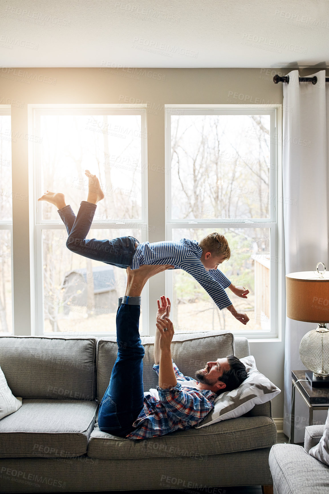 Buy stock photo Dad, son and support on couch with fly for bonding, dream for superhero energy or childhood fantasy. Father, boy child and legs for airplane game or pilot on sofa, relax with flight in family home