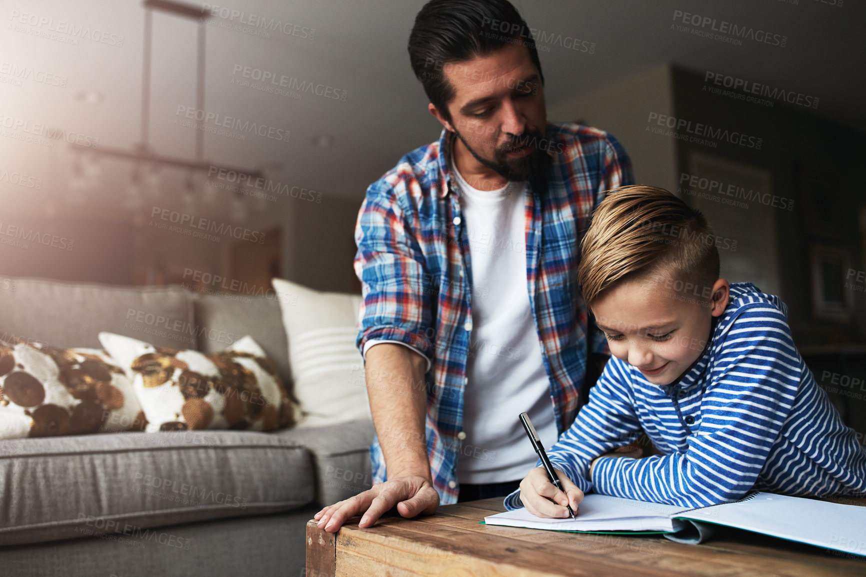 Buy stock photo Shot of a father helping his little son with his homework
