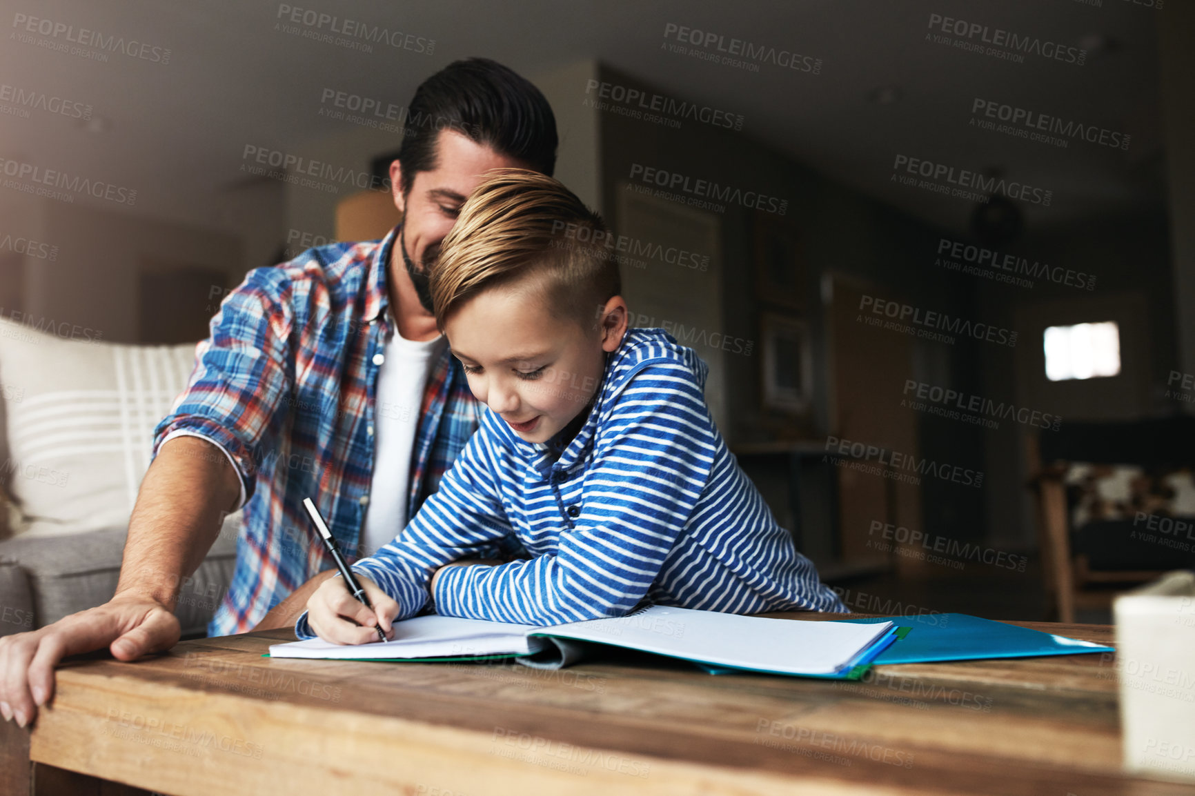 Buy stock photo Shot of a father helping his little son with his homework