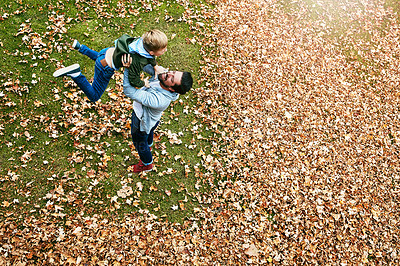 Buy stock photo Shot of a father and his little son playing in the autumn leaves outdoors